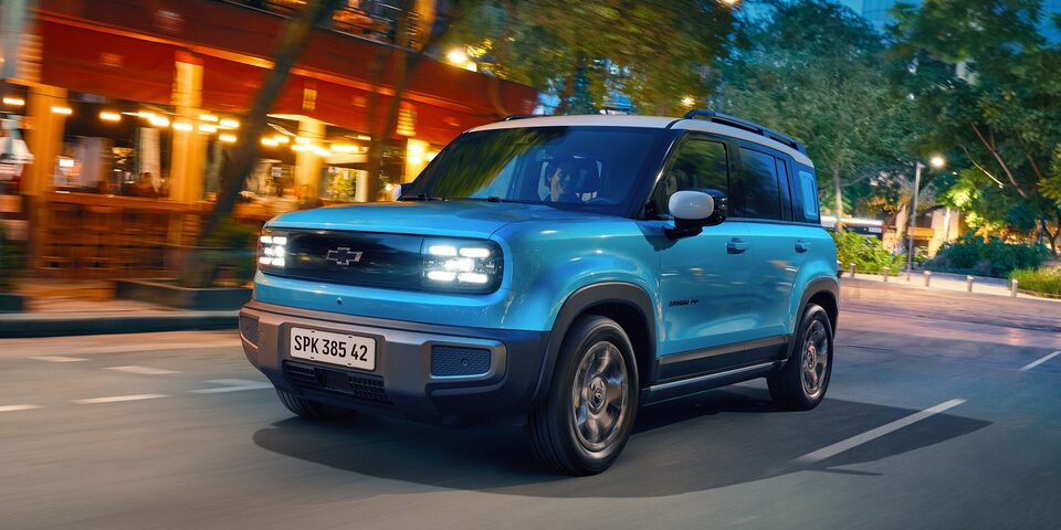 Chevrolet Spark EUV color Azul Aqua condiendo en camino urbano.