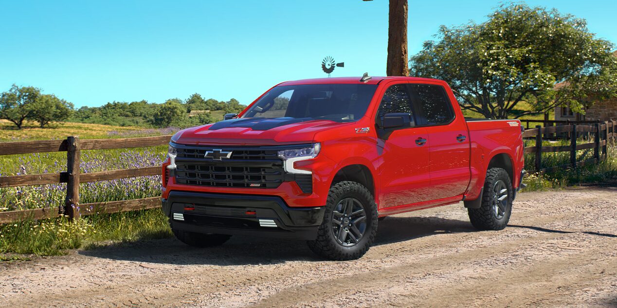 Chevrolet Silverado Z71 estacionada en un camino de tierra con un campo de fondo.