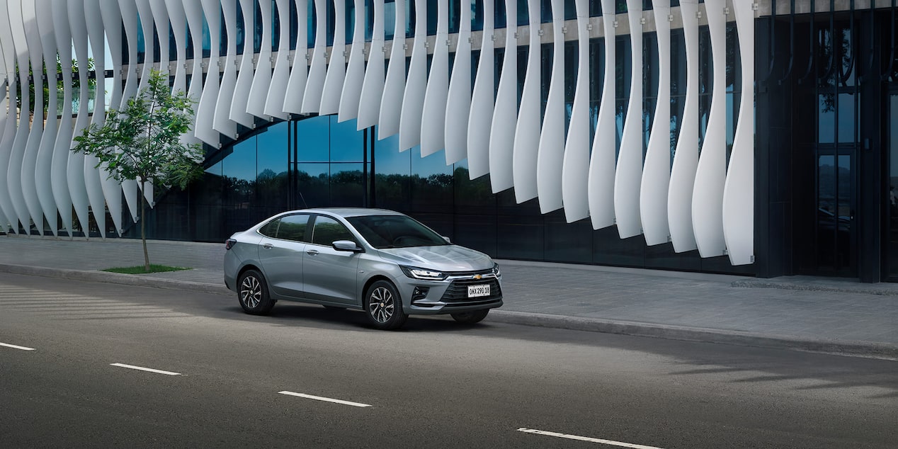 Vista lateral frontal del Chevrolet Onix Plus estacionado en área urbana
