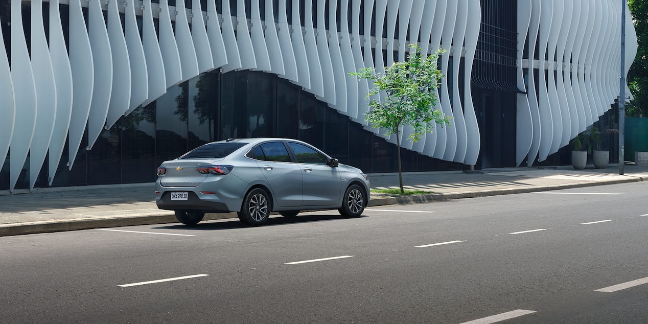 Vista lateral trasera del Chevrolet Onix Plus estacionado en área urbana