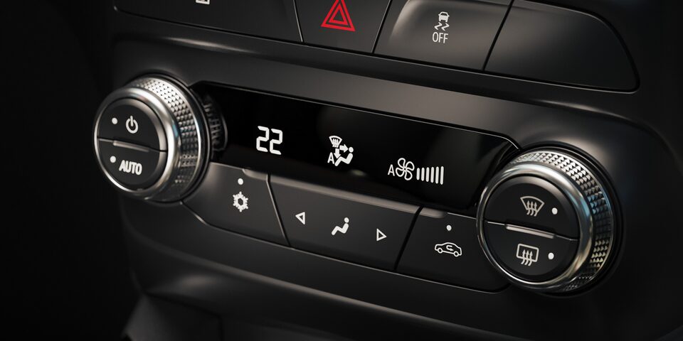 Panel de control del climatizador en el interior de una Chevrolet Montana, con perillas cromadas, pantalla digital central que marca 22 grados y botones para ajustar ventilación, temperatura y modo de circulación de aire.