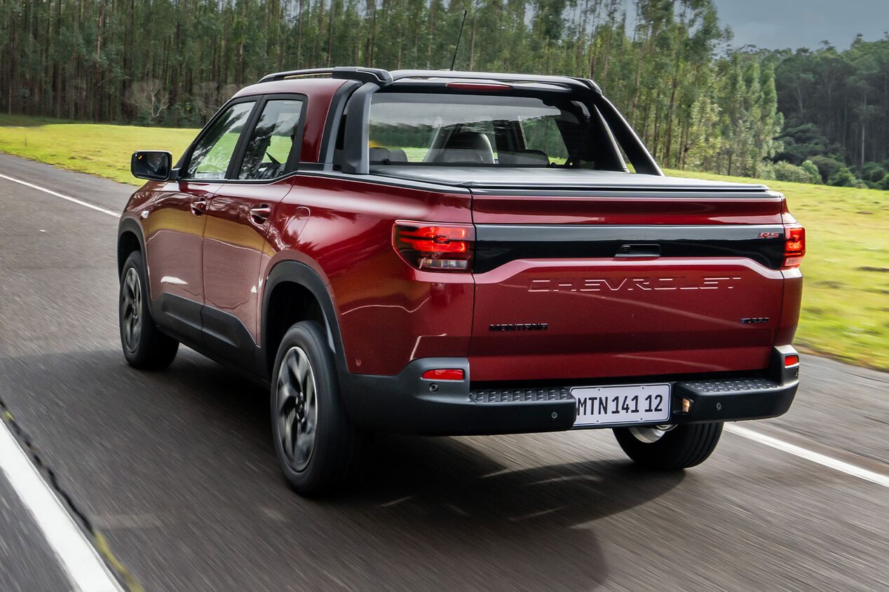 Imagen de una Chevrolet Montana estacionada en una zona descampada al aire libre vista desde atrás.