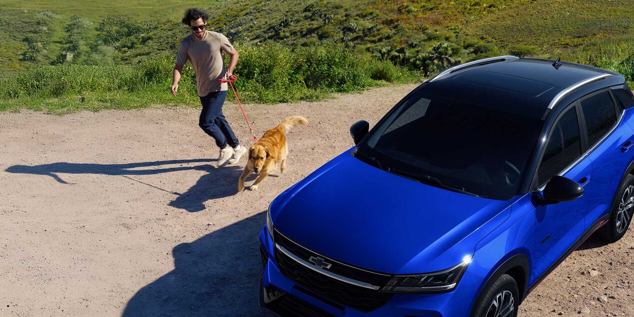 Chevrolet Groove estacionada con un hombre y un perro caminando cerca.